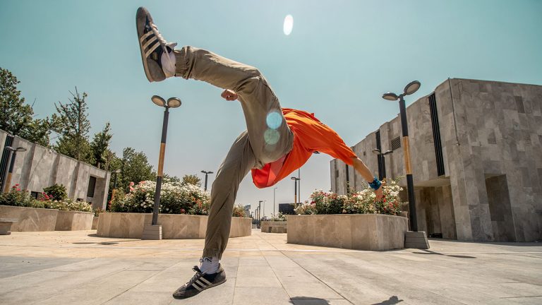 Ein Parkour-Sportler spring über einen urbanen Platz.