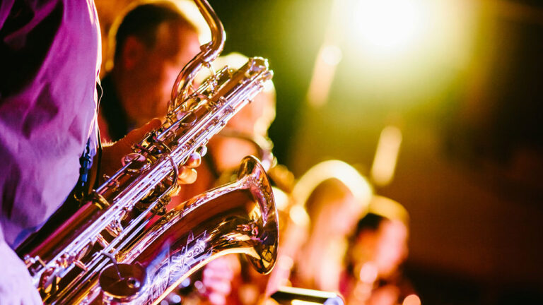 Ein Saxophonspieler mit Band bei einem Konzert.