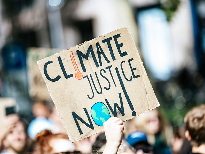 Ein Demo-Schild mit der Aufschrift „Climate Justice Now!“