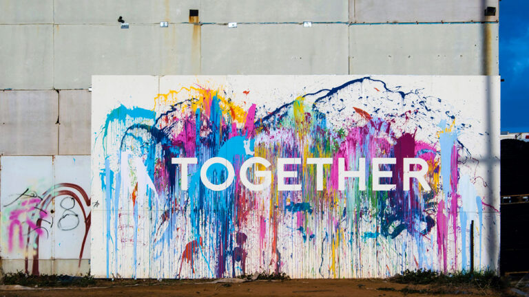 Bunt bemalte Wand mit dem Schriftzug „TOGETHER“.